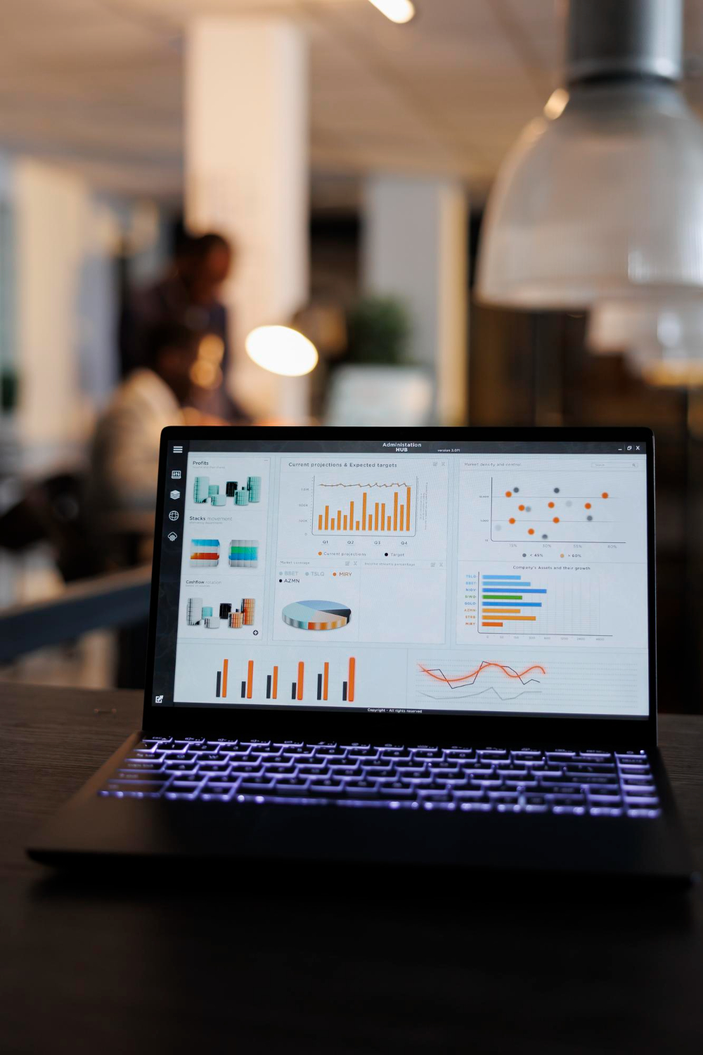 Laptop computer with marketing statistics graphs on screen